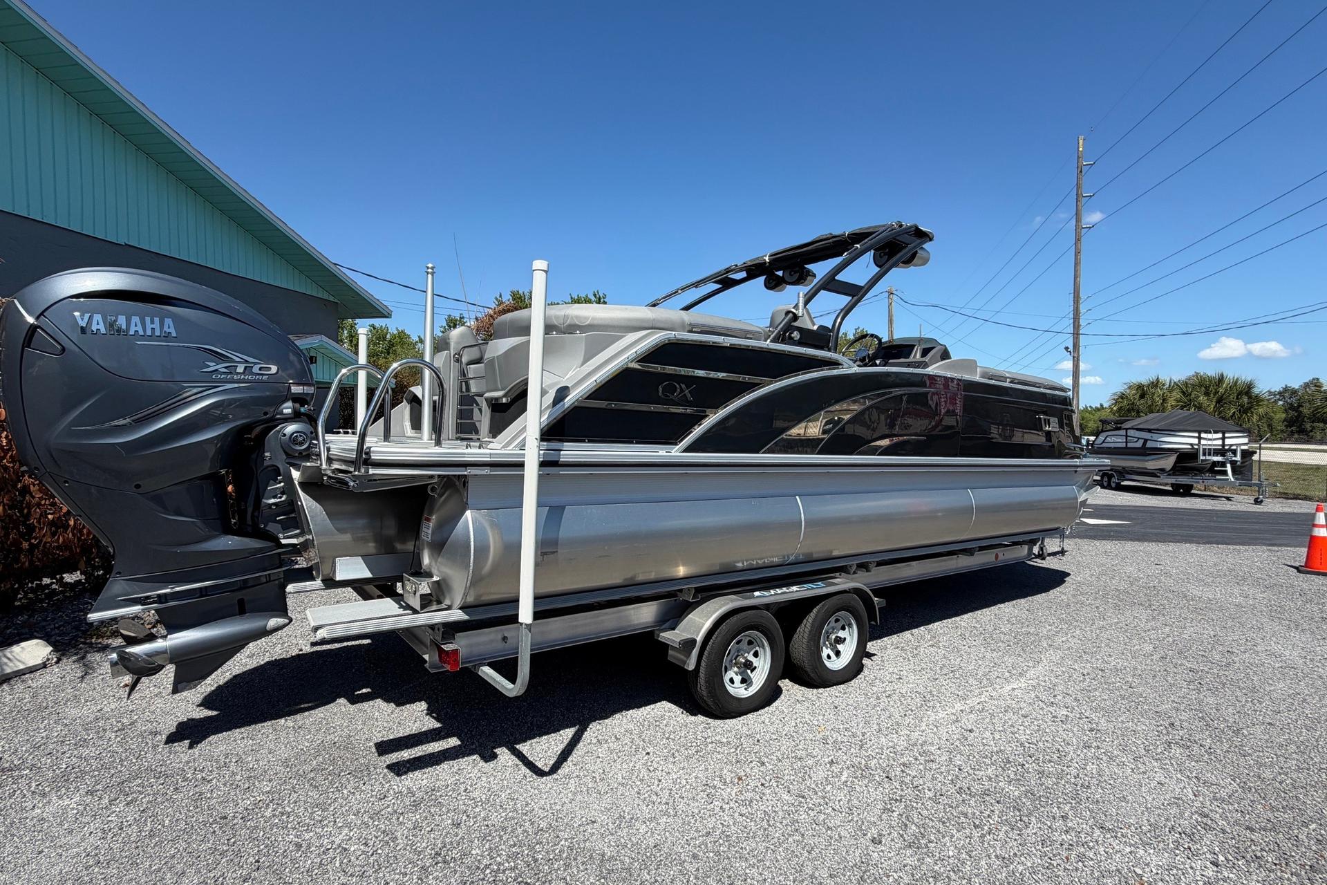 2022 Bennington 25 QX pontoon boat with Yamaha XTO outboard engine on trailer.