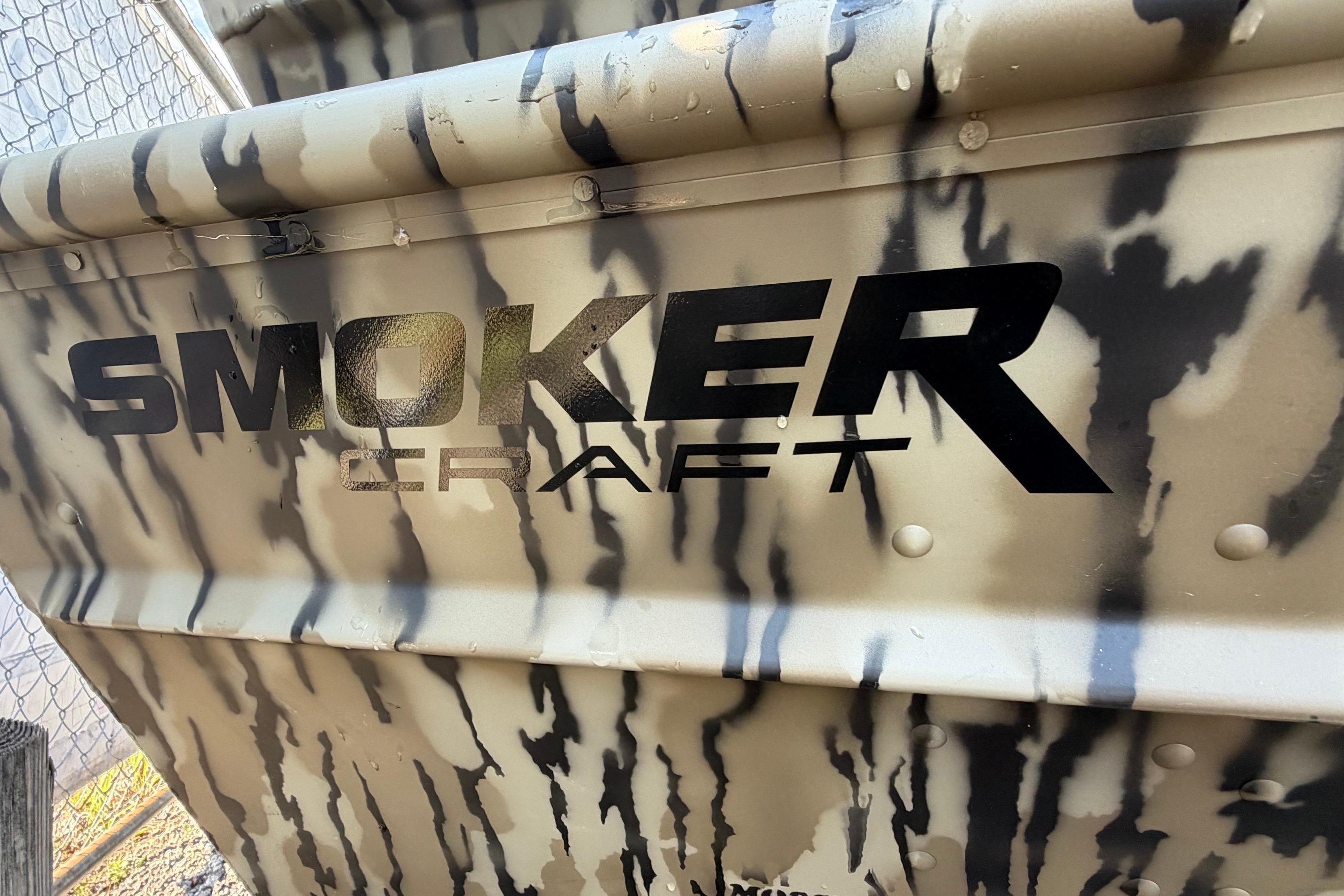 2026 Smoker Craft 1432 Jon boat with camouflage pattern and bold logo.