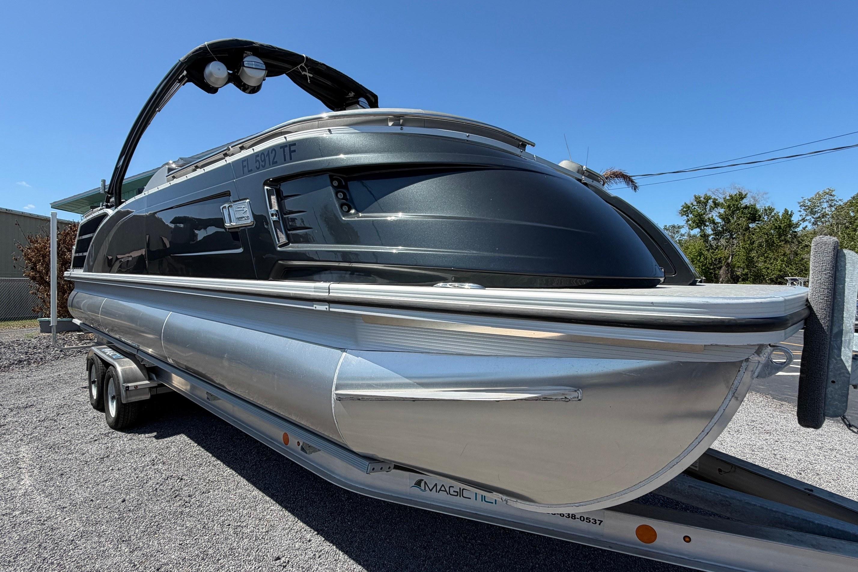 2022 Bennington 25 QX pontoon boat on trailer under clear blue sky.