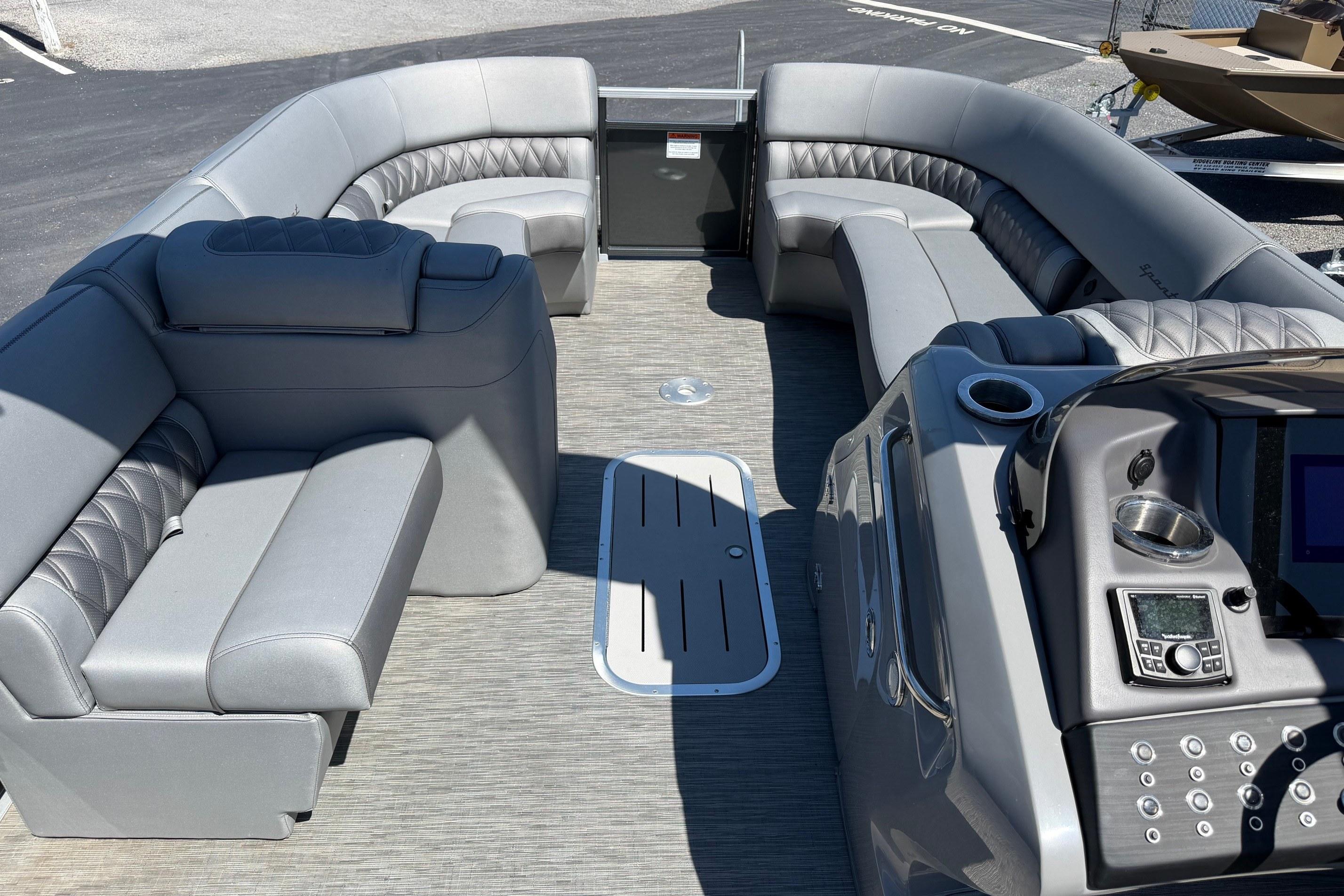 2022 Bennington 25 QX pontoon boat interior with luxurious gray seating and modern dashboard.