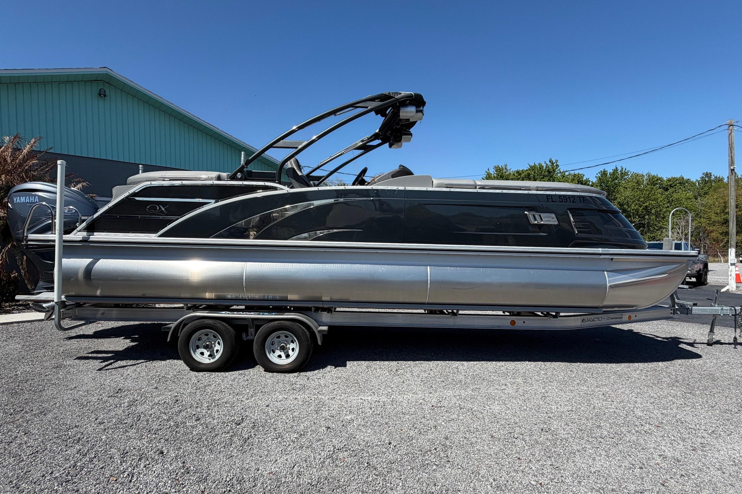 2022 Bennington 25 QX pontoon boat on trailer, parked outdoors.